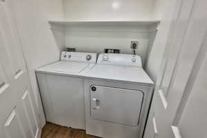 Laundry room featuring dark wood finished floors and independent washer and dryer