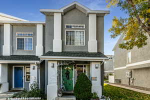 View of front of house featuring a shingled roof and stucco siding