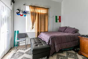 Tiled bedroom with a closet and a textured wall