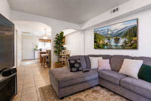 Living area featuring arched walkways and light tile patterned flooring