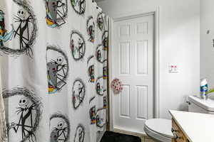 Full bath with vanity, light tile patterned floors, a shower with curtain, and a textured wall