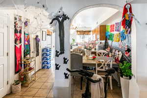 Dining space featuring light tile patterned floors and arched walkways