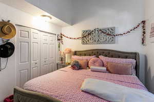 Bedroom with a textured wall and a closet