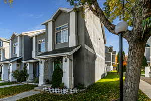 Traditional home with stucco siding, a front yard, and a residential view