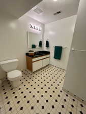 Bathroom featuring a textured ceiling and vanity