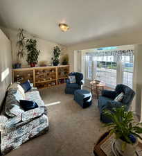 Carpeted living area featuring a textured ceiling