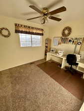 Upstairs carpeted home office featuring a ceiling fan