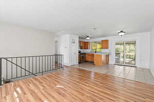 Unfurnished living room featuring light wood-type flooring and baseboards