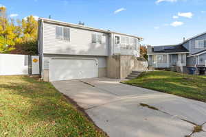 View of front of property featuring concrete driveway and an attached garage