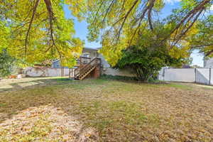 Fenced backyard featuring stairway and a wooden deck