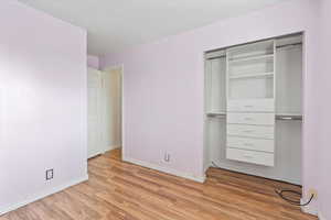 Unfurnished bedroom with light wood finished floors and a closet