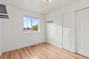 Unfurnished bedroom with light wood finished floors and a closet