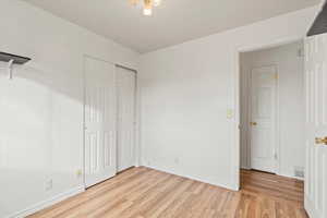 Unfurnished bedroom featuring light wood-style flooring and a closet