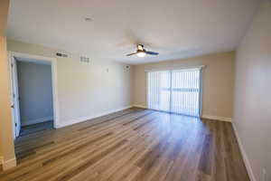 Spare room featuring wood finished floors, a textured ceiling, and ceiling fan