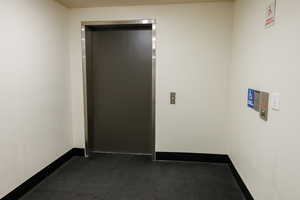 Hall featuring elevator and baseboards