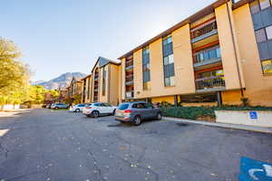 View of apartment building / complex featuring uncovered parking and a mountain view