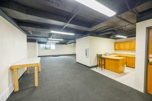 Below grade area featuring light carpet and light tile patterned flooring