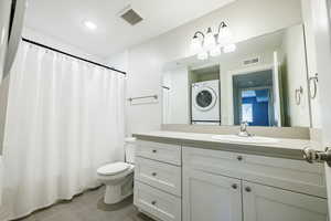 Bathroom featuring a shower with shower curtain, vanity, light tile patterned flooring, and recessed lighting