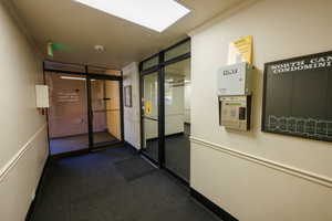Corridor with ornamental molding and dark carpet