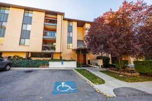 View of apartment building / complex with uncovered parking