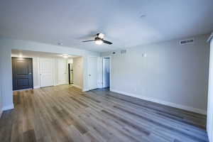 Unfurnished living room featuring wood finished floors and a ceiling fan