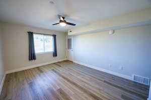 Spare room featuring light wood-style flooring, a ceiling fan, and a textured ceiling