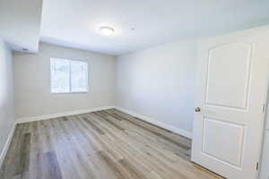Empty room with a textured ceiling and light wood-style floors