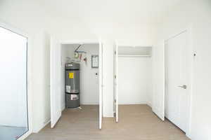 Utility room with strapped water heater and Closet