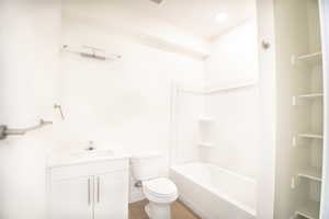 Full bath with vanity, shower / washtub combination, and light wood-style floors