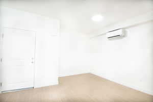 Livingroom with light wood-style floors and a wall unit AC