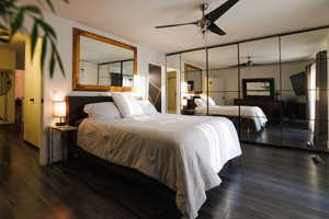 Bedroom with dark wood finished floors, a closet, and a ceiling fan