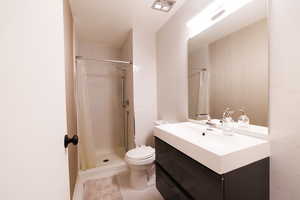Full bathroom featuring vanity, a stall shower, and light tile patterned floors