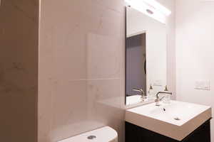Bathroom with vanity and a marble finish shower