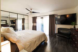Bedroom featuring dark wood-style floors, a ceiling fan, and access to exterior