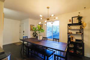Dining room featuring a chandelier and baseboards