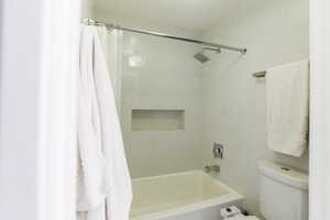 Bathroom with shower / bath combination with curtain and toilet