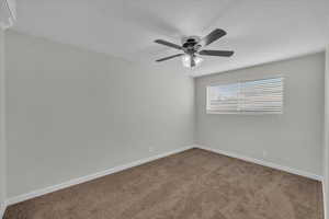 Unfurnished room featuring carpet floors, a wall mounted AC, and a ceiling fan