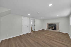 Unfurnished living room featuring recessed lighting, wood finished floors, and a fireplace
