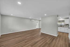 Unfurnished living room with recessed lighting and dark wood-style flooring