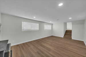Below grade area featuring wood finished floors, recessed lighting, and stairway