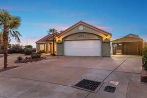 Mediterranean / spanish home with driveway, a tile roof, a gate, stucco siding, and an attached garage
