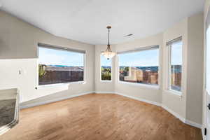 Unfurnished dining area with light wood-style flooring and baseboards