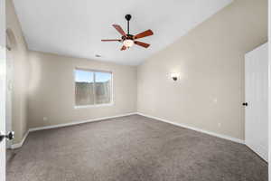 Unfurnished room featuring carpet, a ceiling fan, and lofted ceiling