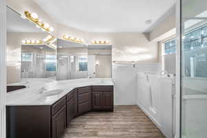 Full bath featuring double vanity, a stall shower, and wood finish floors