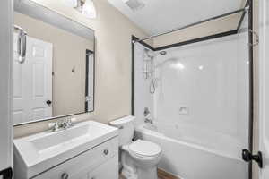 Bathroom with bathtub / shower combination, vanity, and wood finished floors