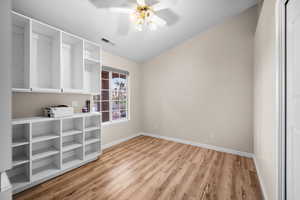 Spare room with light wood-style flooring, lofted ceiling, and ceiling fan