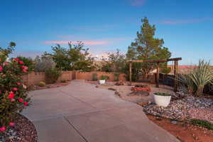 Patio terrace at dusk featuring a fenced backyard