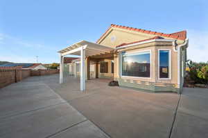 Rear view of property with a patio, a pergola, a tiled roof, stucco siding, and a fenced backyard
