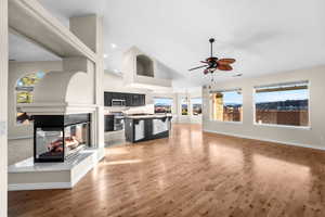 Unfurnished living room featuring a multi sided fireplace, light wood-style floors, recessed lighting, and ceiling fan