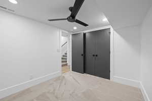 Unfurnished bedroom featuring recessed lighting, light colored carpet, a closet, and a ceiling fan